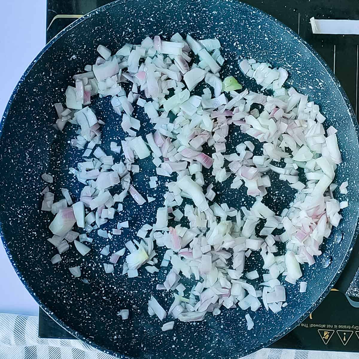 Onions being sauteed in a pan.