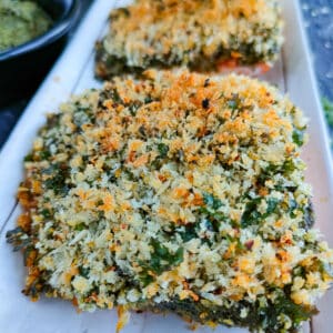Easy panko pesto crusted salmon fillets on a white plate.