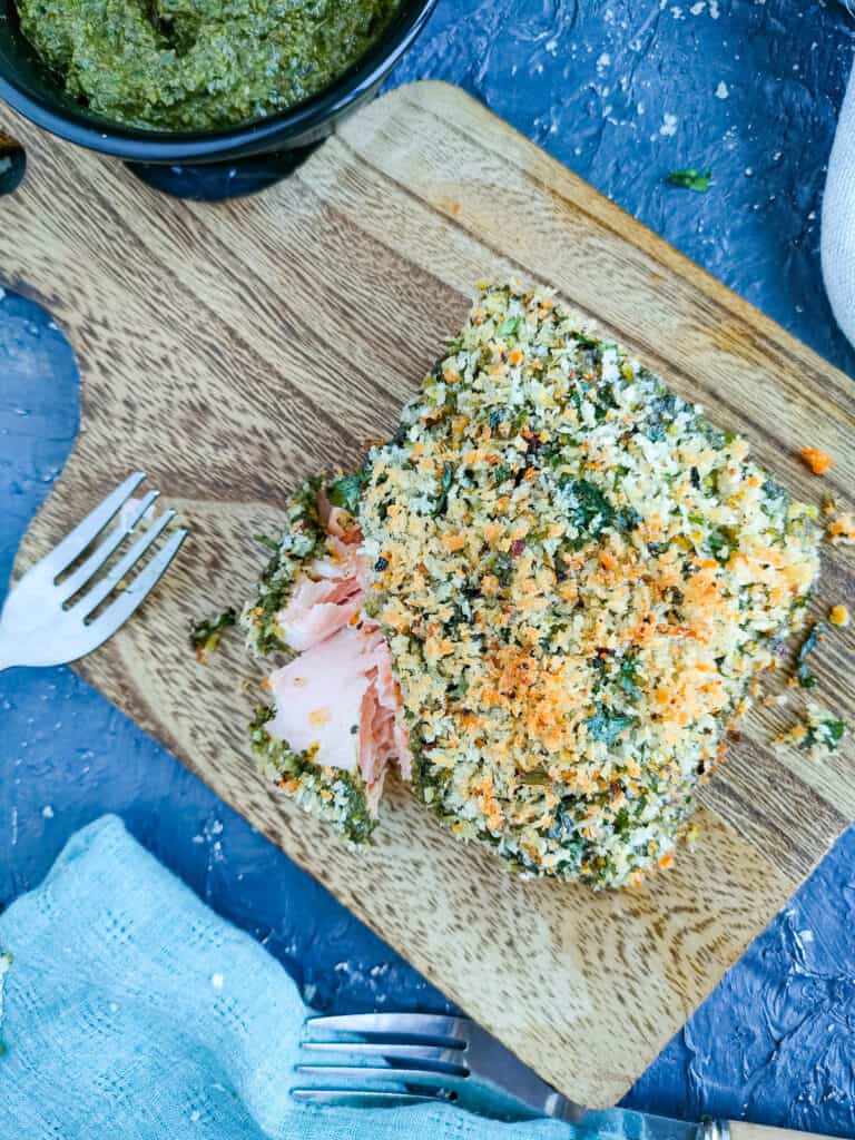 Pesto salmon with Panko crust on a wooden board.