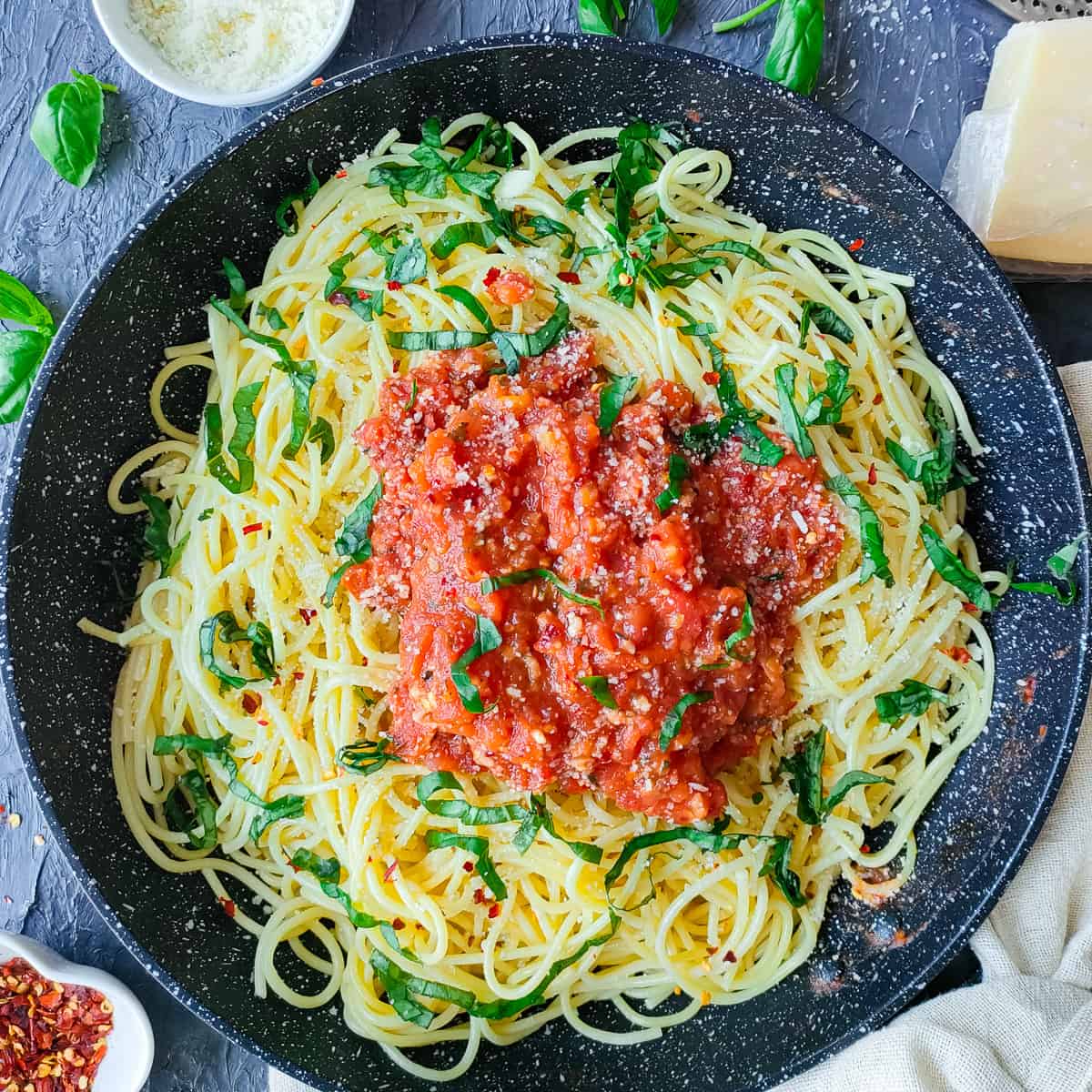 Cooked spaghetti with authentic arrabiata sauce in a pan.