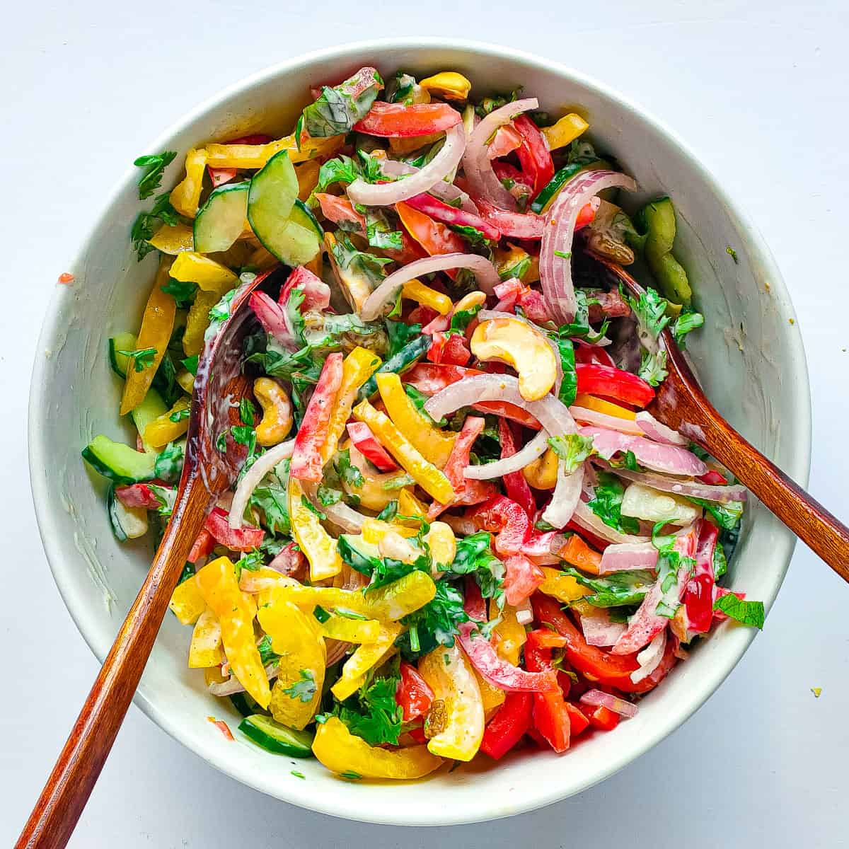 Vegetables with dressing in a white bowl.