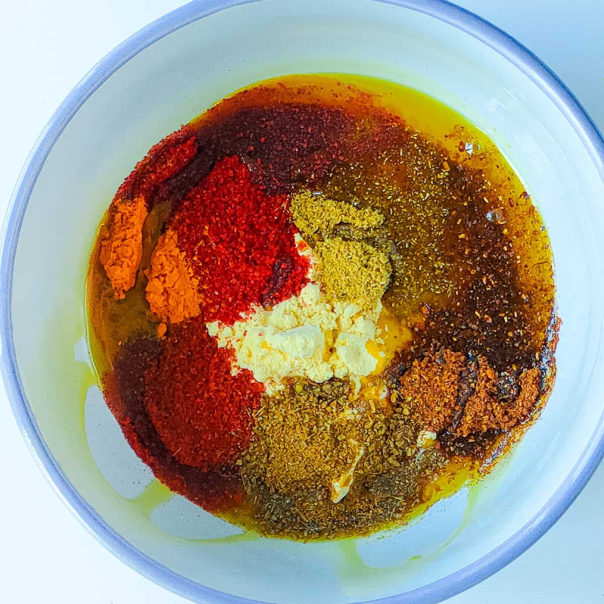 Spices for fish tandoori recipe in a small white bowl.