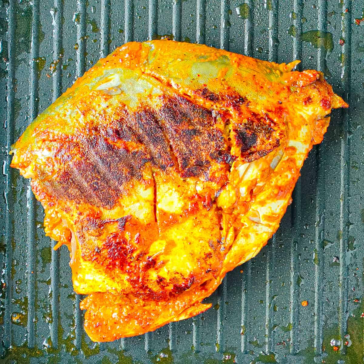 Browned fish tandoori on a grill pan.