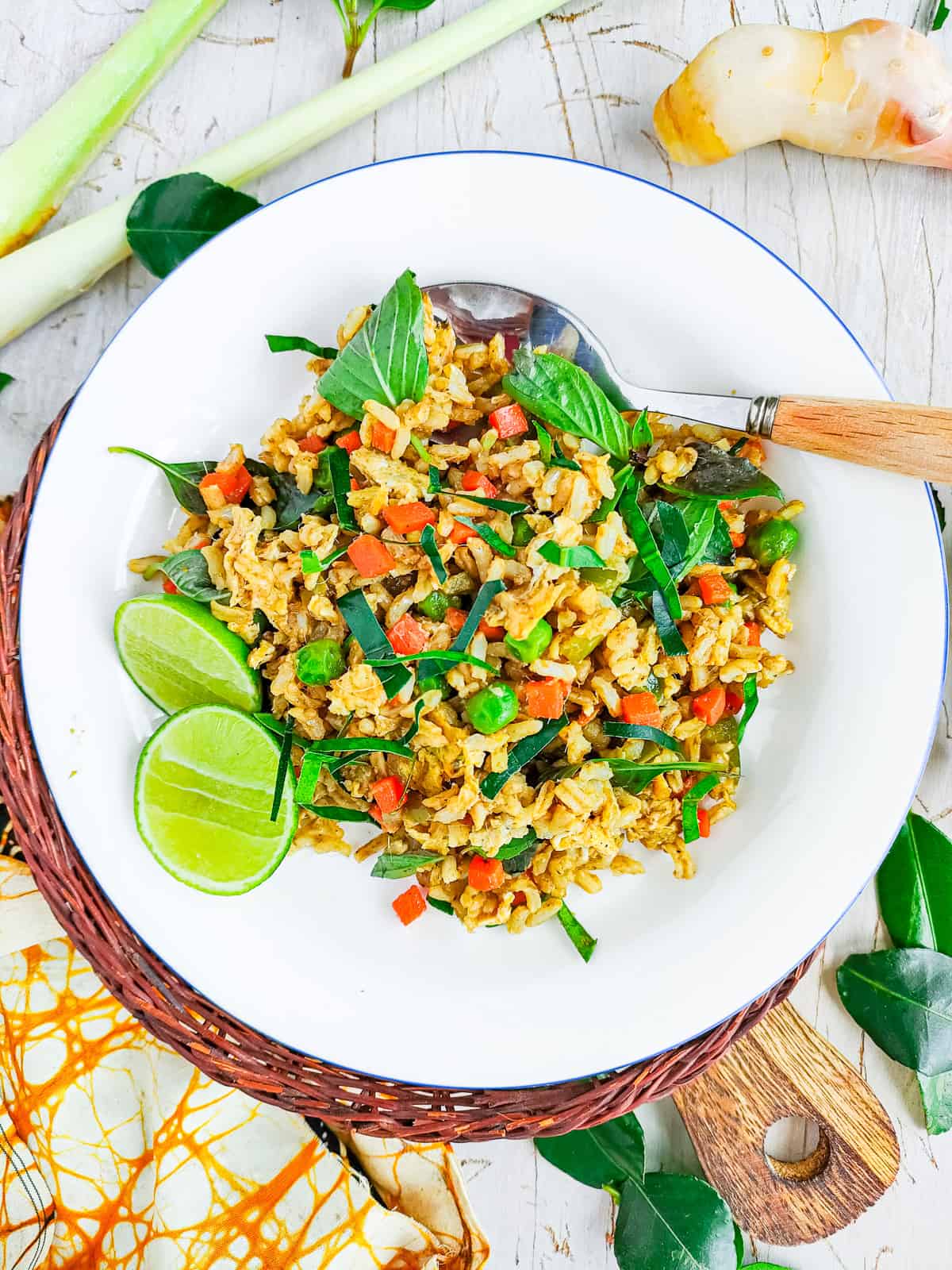 Green curry fried rice on a white plate with a spoon.