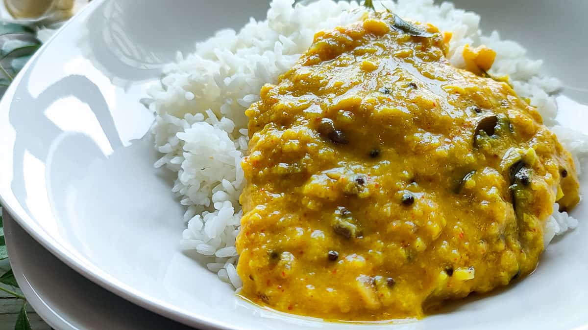 Kerala dal curry served with rice on a white plate.