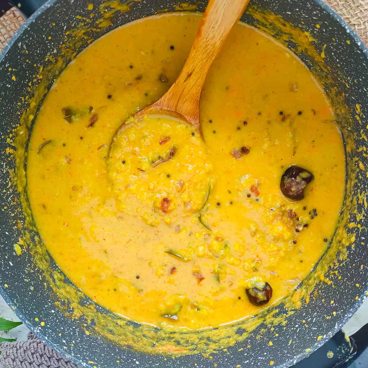 Parippu curry with coconut in a pot with a ladle.