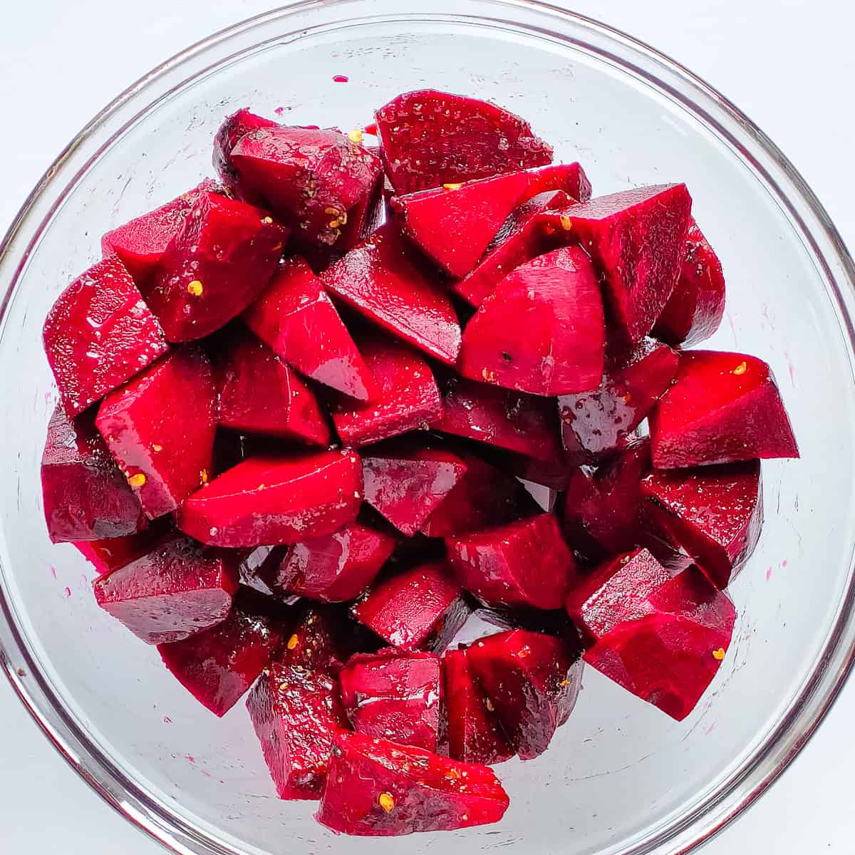 Seasoned beetroot cubes in a glass bowl.