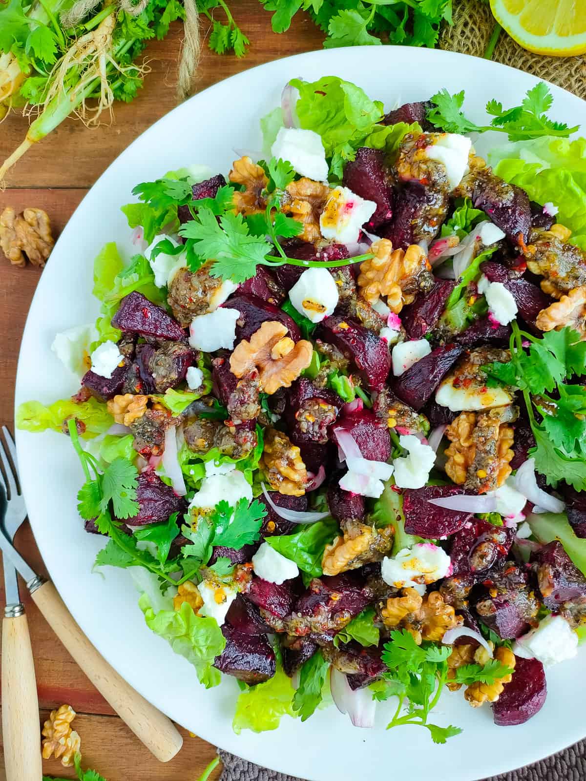 Beetroot salad with feta and walnuts on a white plate.