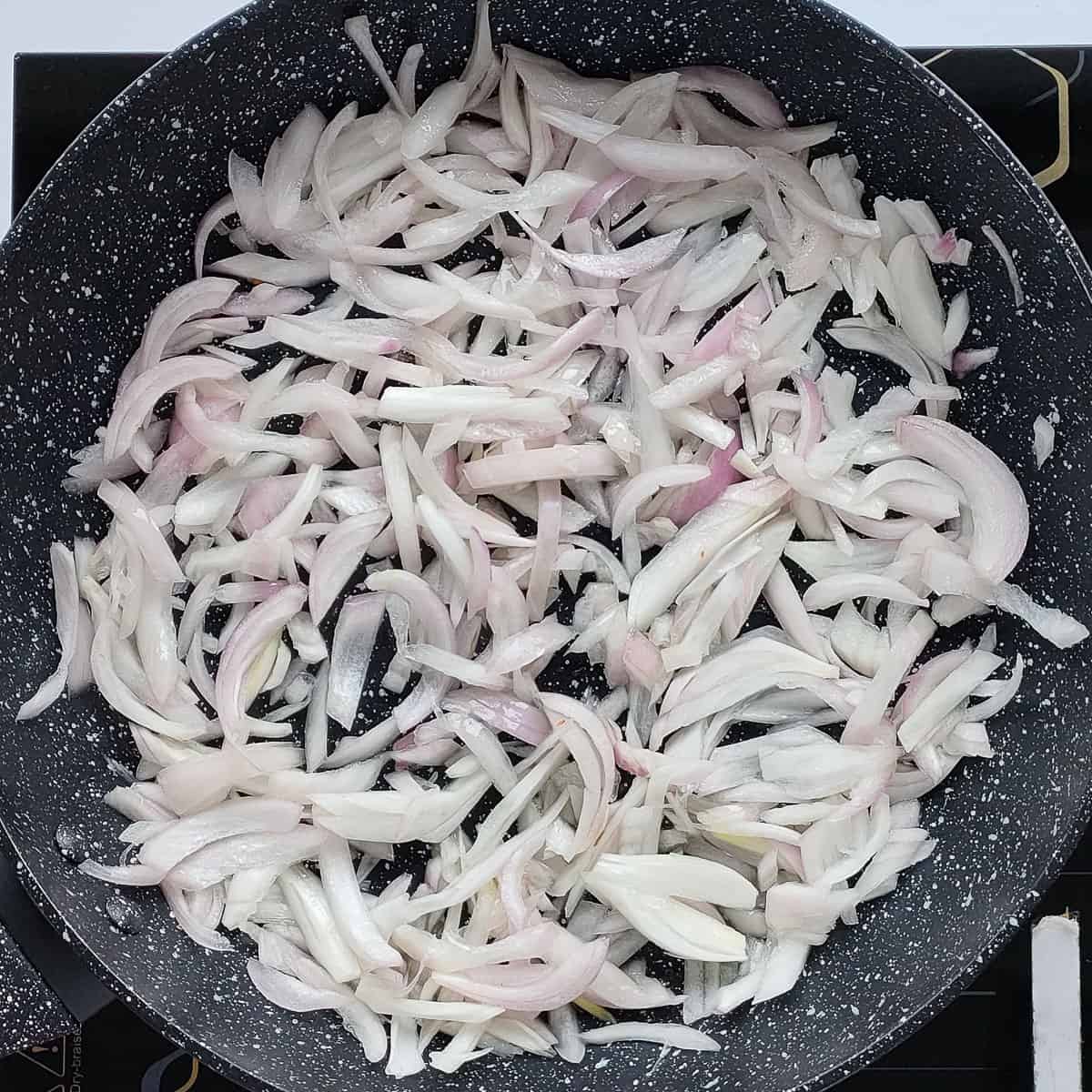 Onions being sauteed in a pan.