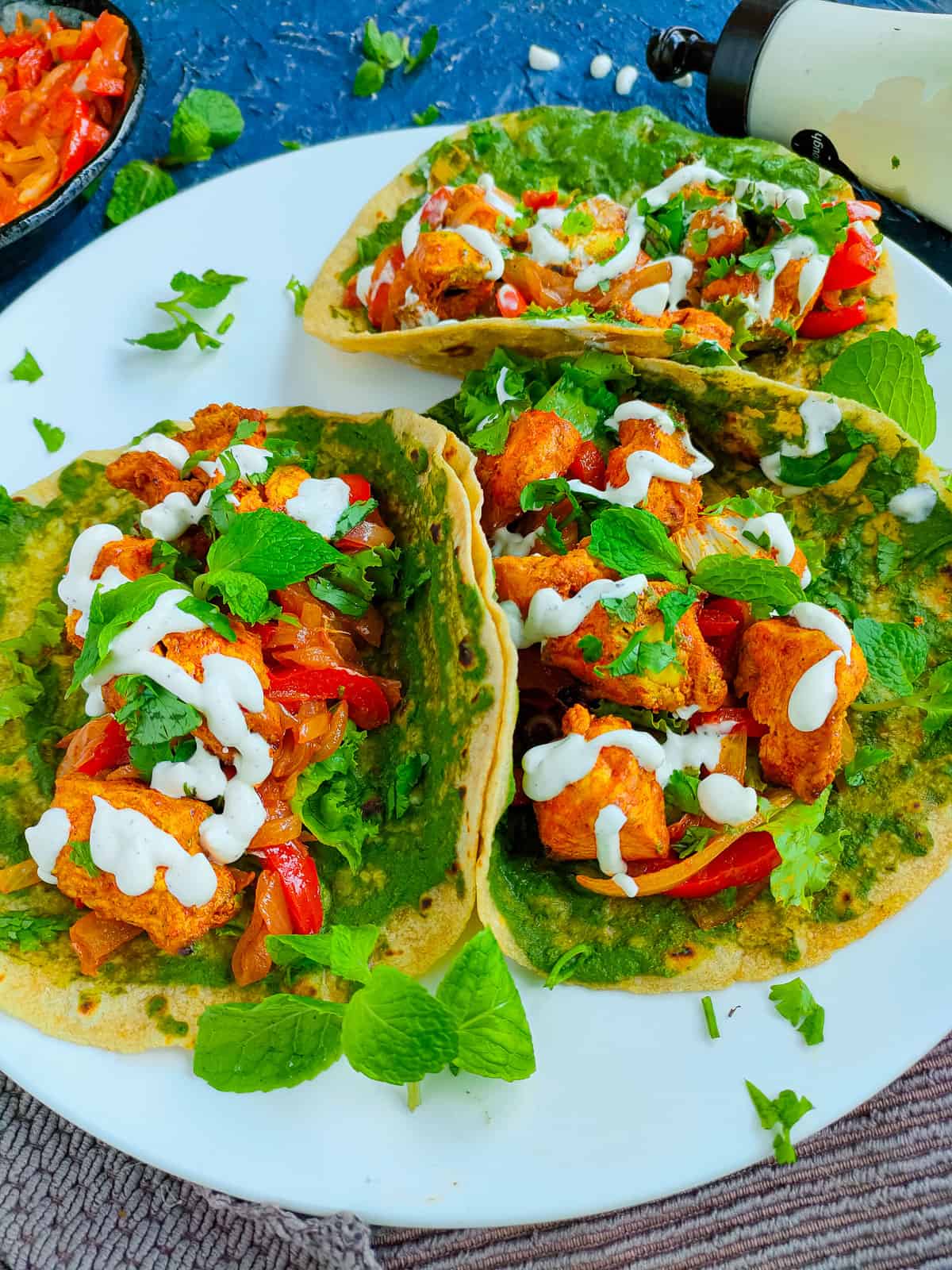 3 chicken tandoori wraps on a white plate.