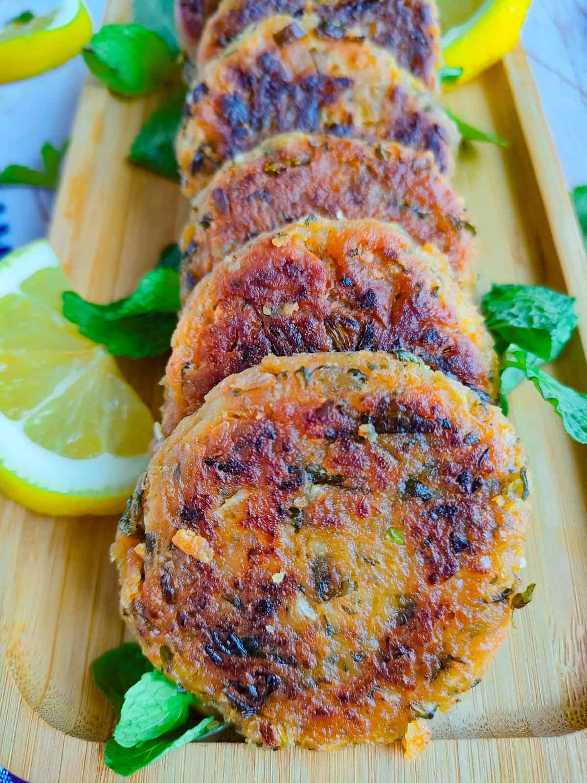 Indian chickpea patties on a wooden serving board.