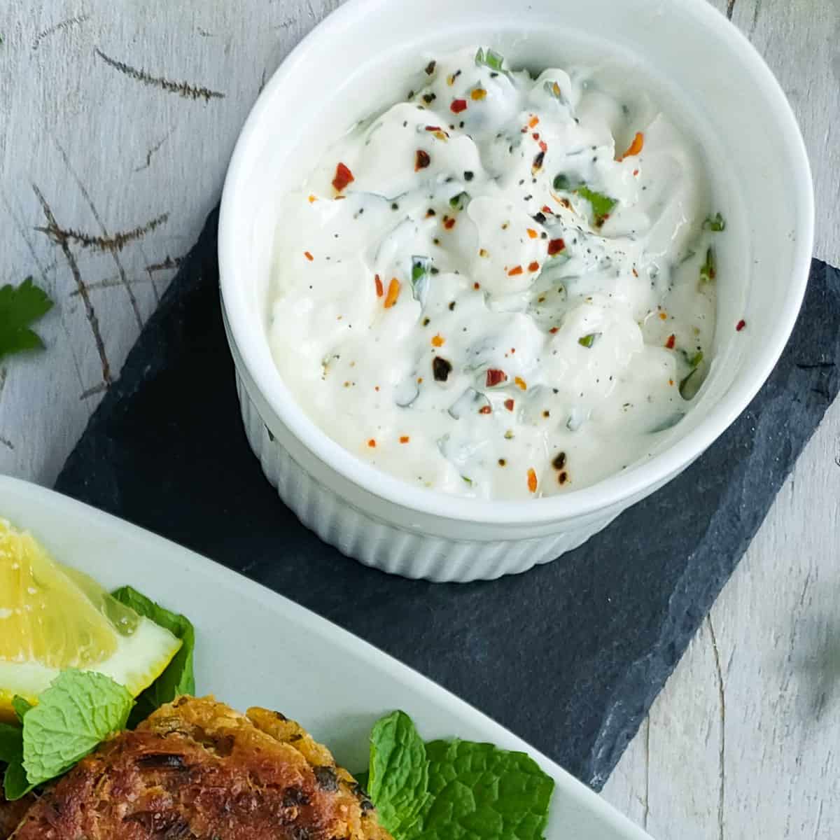 Lemon yogurt sauce in a white bowl.