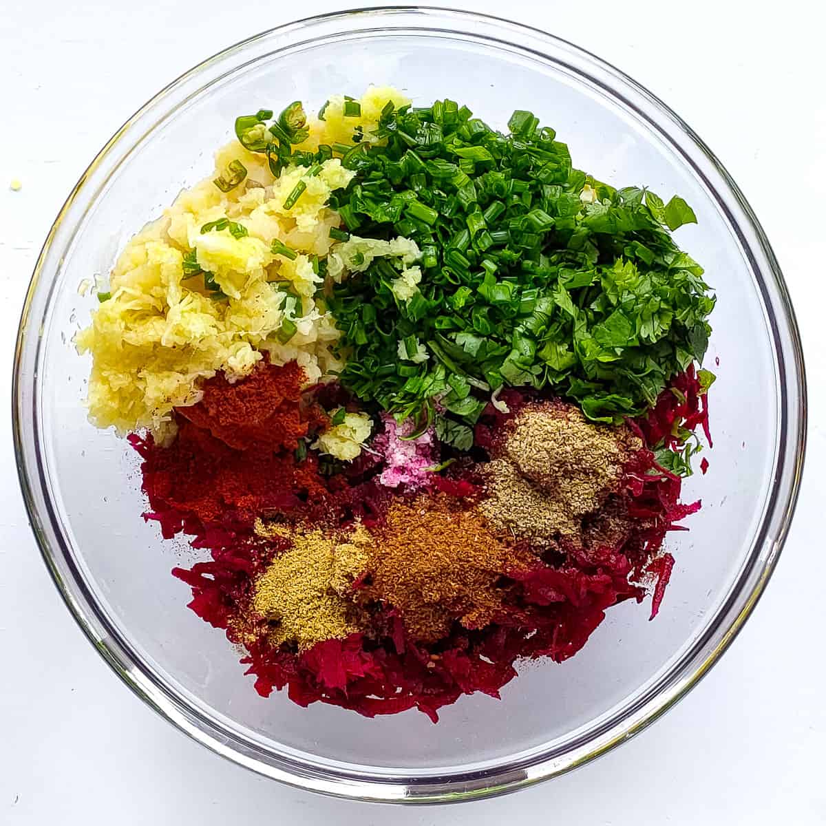 Ingredients for the mixture for making beetroot tikki in a glass bowl.