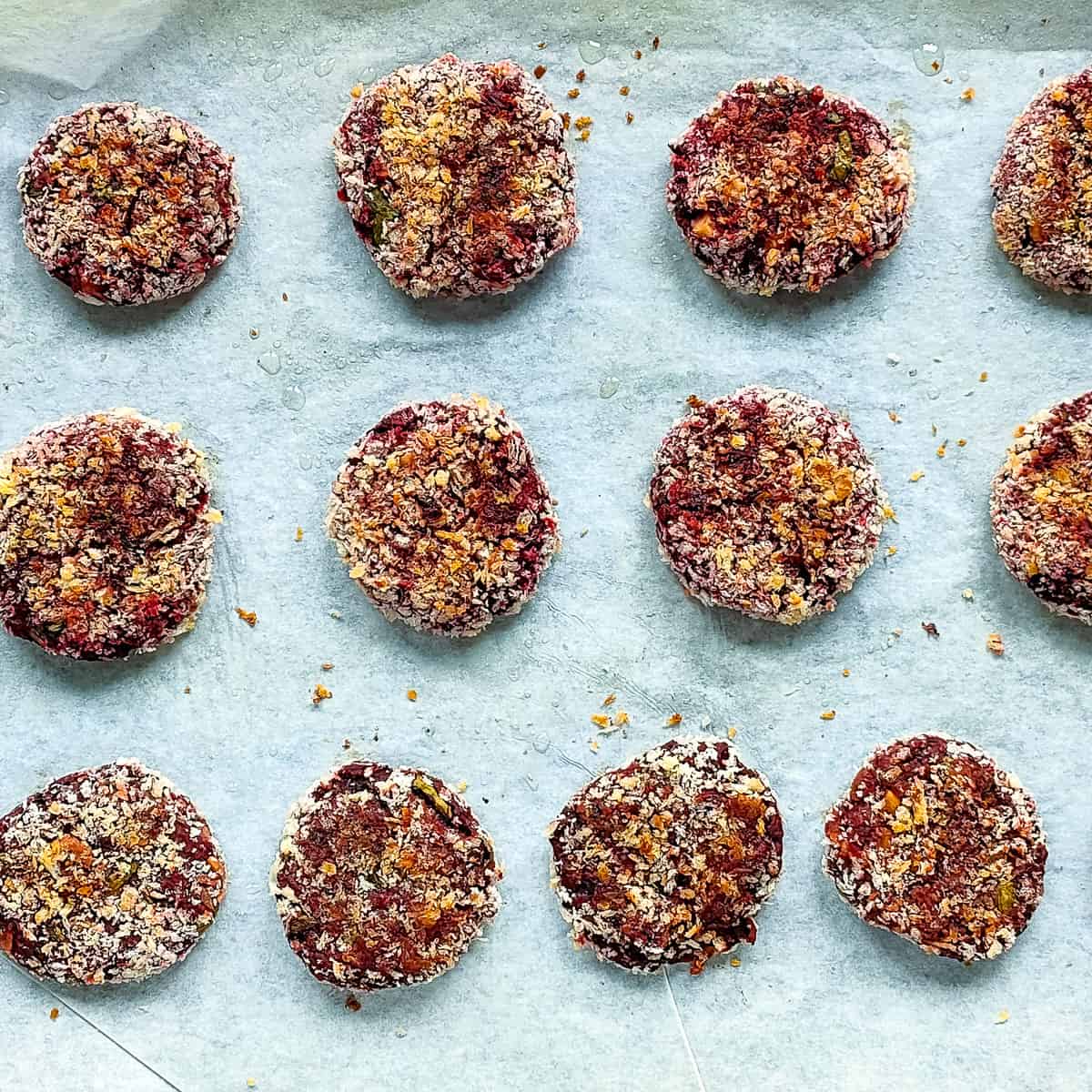 Baked beetroot cutlets on a baking sheet.