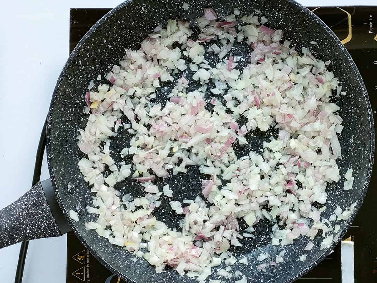 Onions being browned in a saute pan.