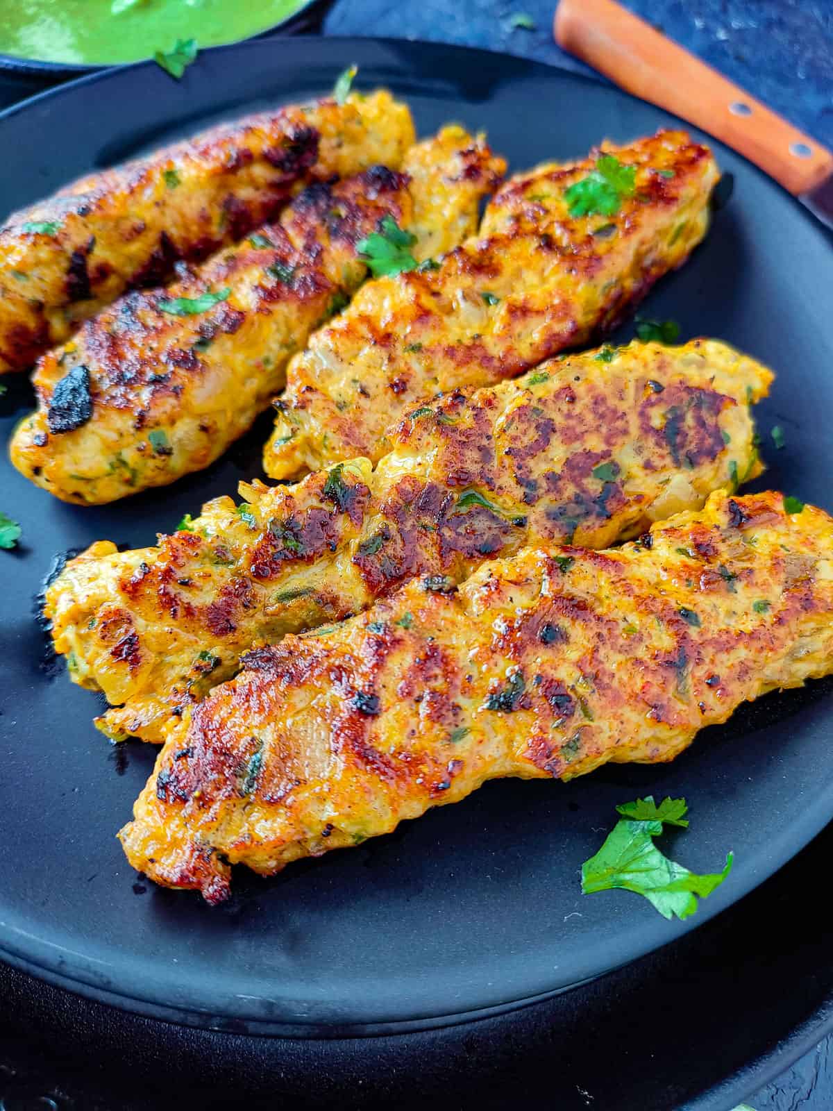 Chicken Keema Kebabs on a black plate.