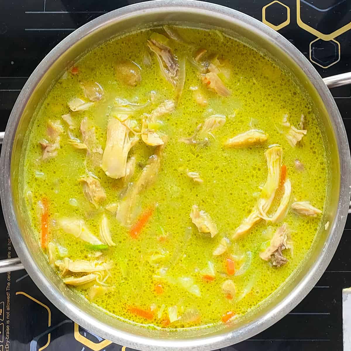 Chicken cilantro soup in a metal soup pot.