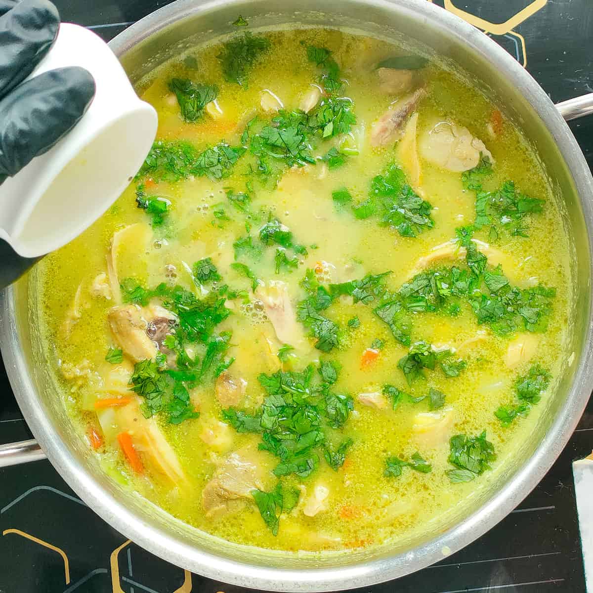 Chicken lemon coriander soup in a metal soup pot.