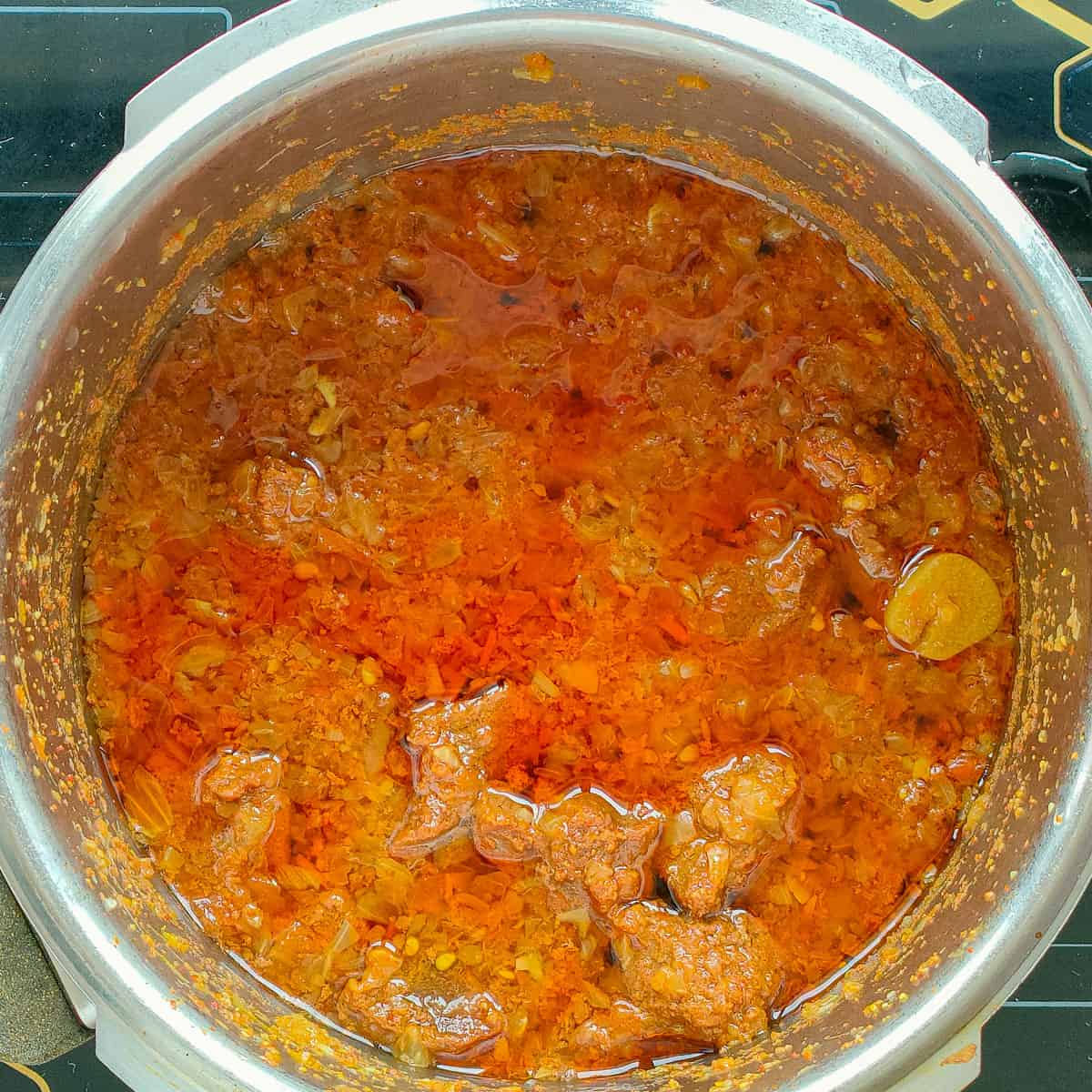 Cooked mutton gravy in a pressure cooker.