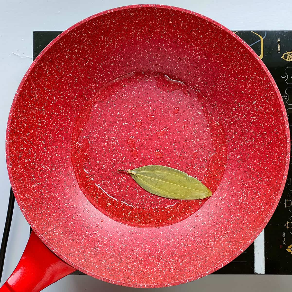 Bay leaf being roasted in a pan.