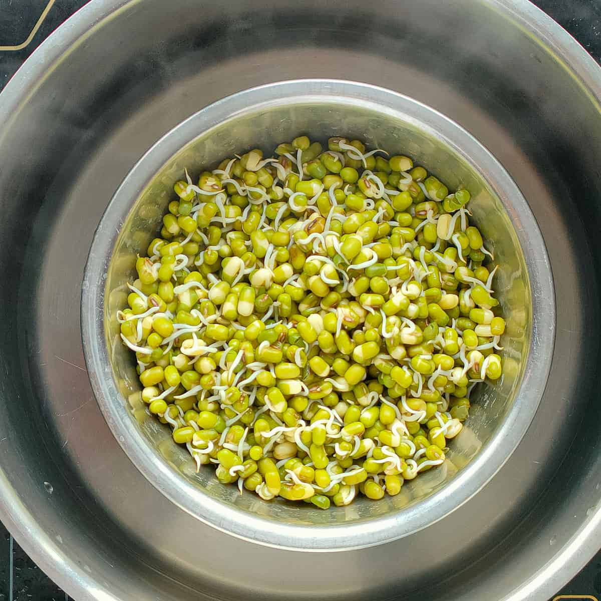 Steamed mung bean sprouts in a metal bowl.