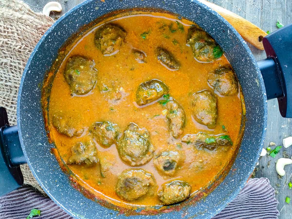 Spinach kofta curry in a cooking pot.