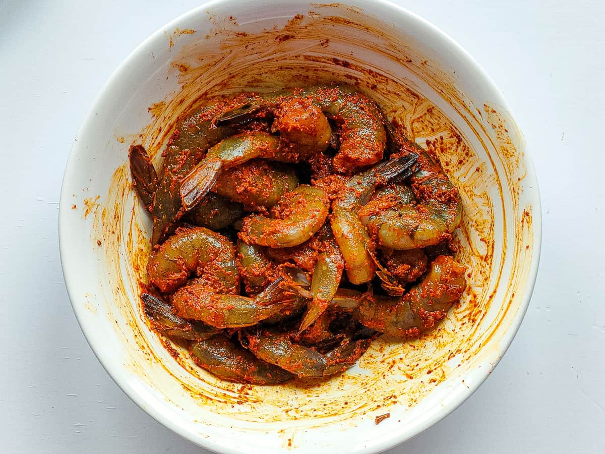Marinated prawns in a small white bowl.