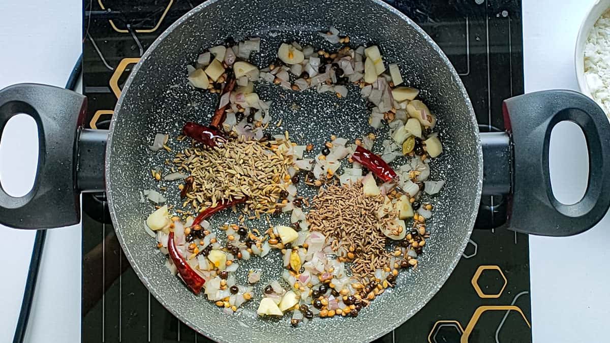 Roasted spices, garlic and onions for chicken masala in a non-stick cooking pot.