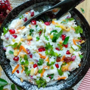 Dahi bhat in a black bowl with a spoon in it.