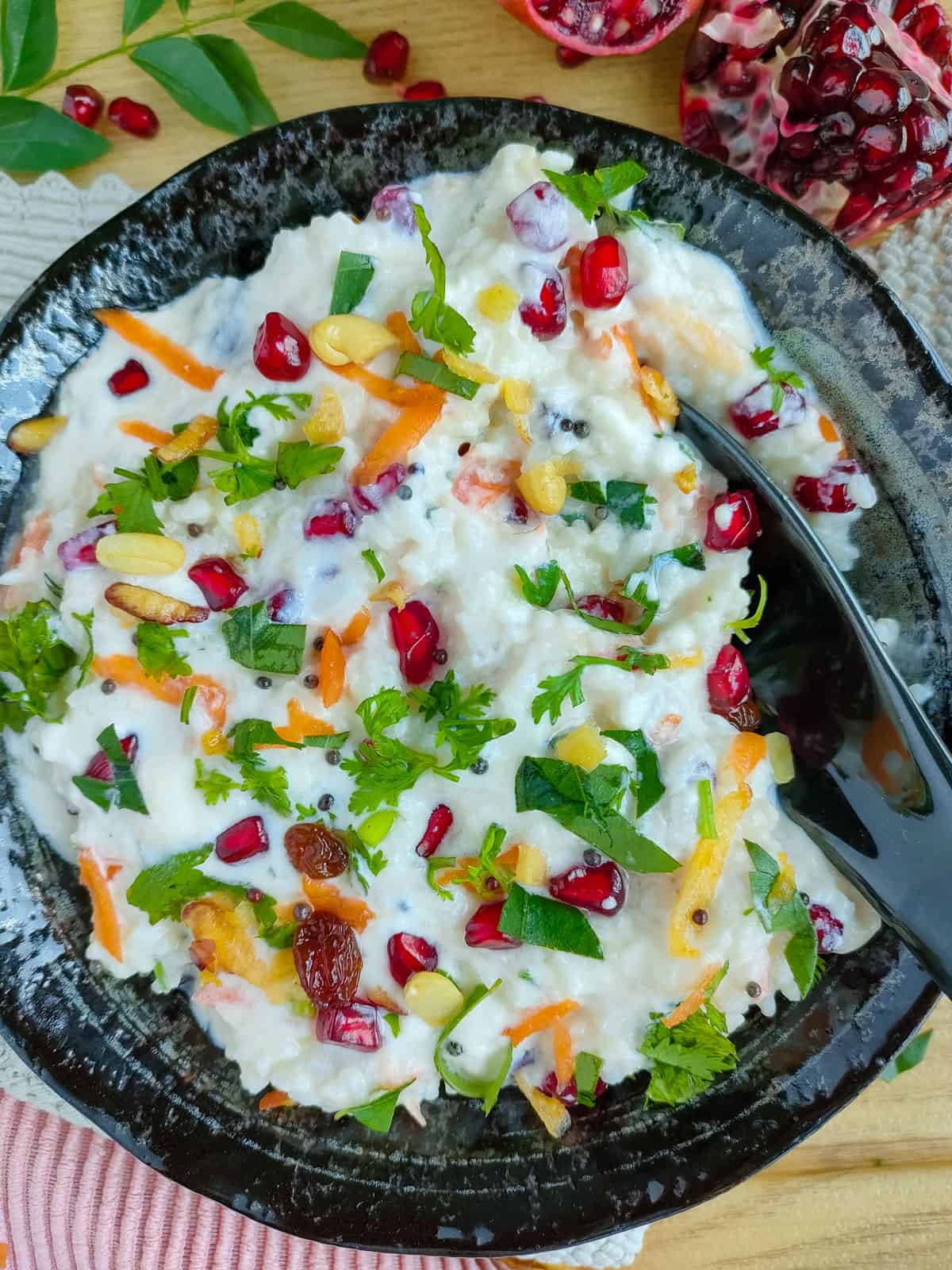 Dahi bhat in a black bowl with a spoon in it.