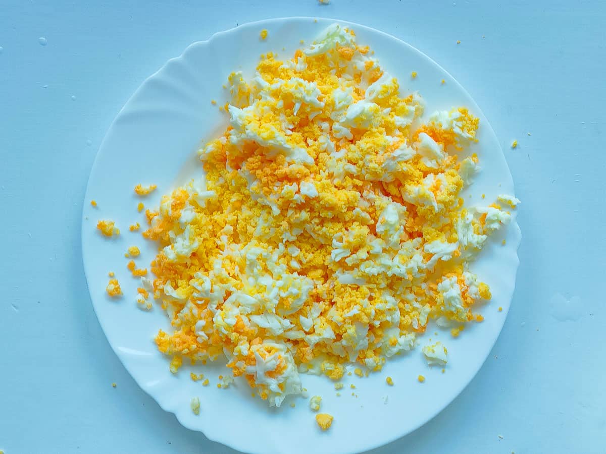 Grated boiled eggs on a white plate.