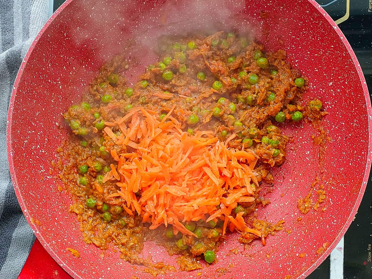 Carrots added to the gravy in a non-stick wok pan.