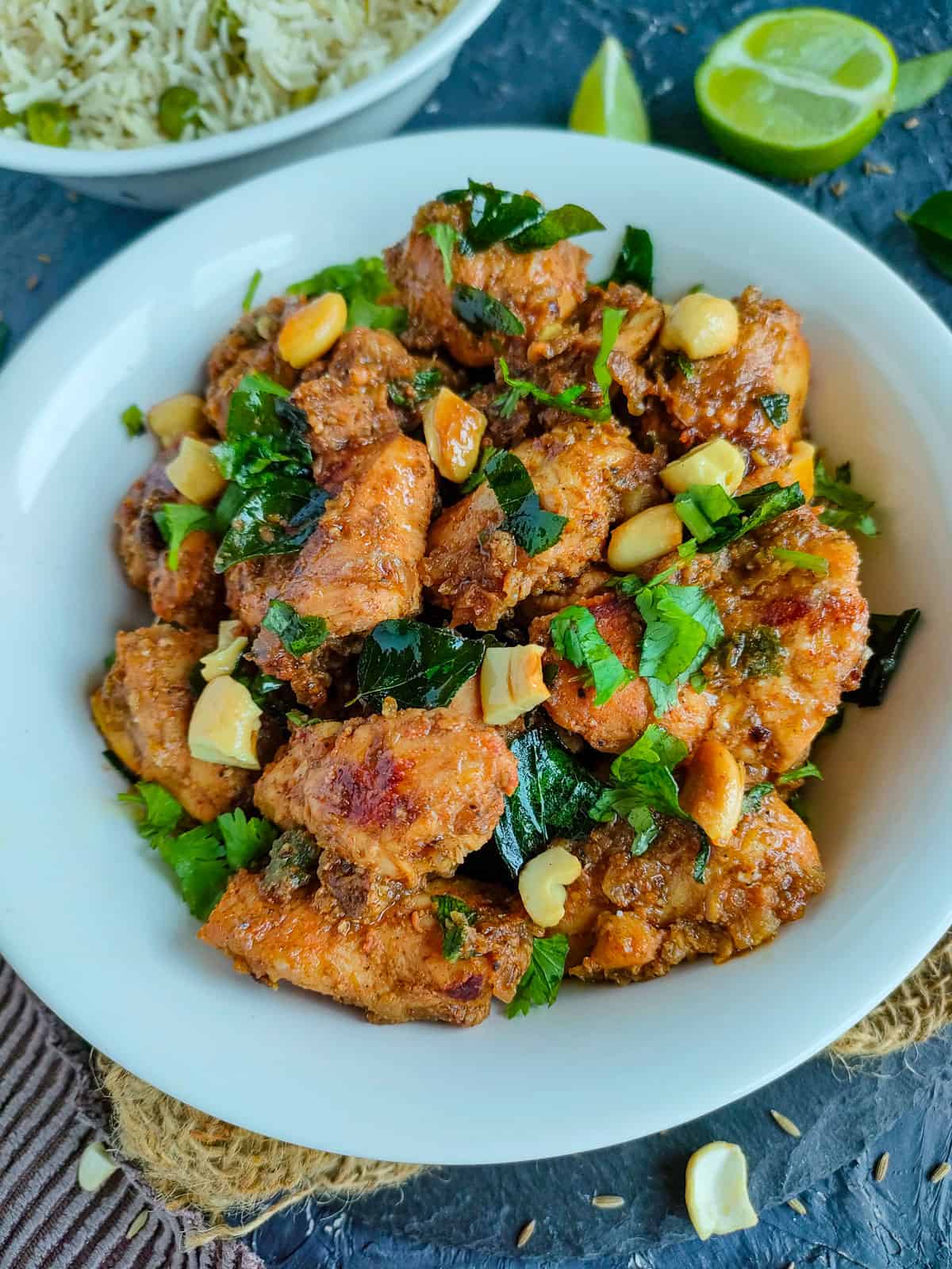 Easy jeera chicken in a white bowl and a bowl of rice next to it.