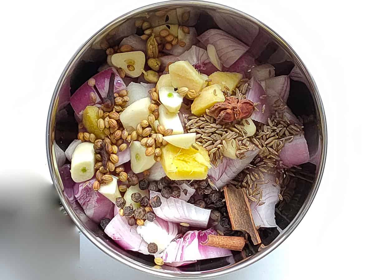 Onions, ginger, garlic and spices in a blender jar.