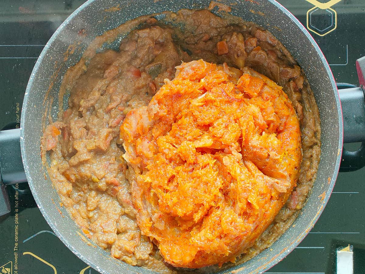 Chicken qeema added to onion and tomato gravy in a non stick pot.