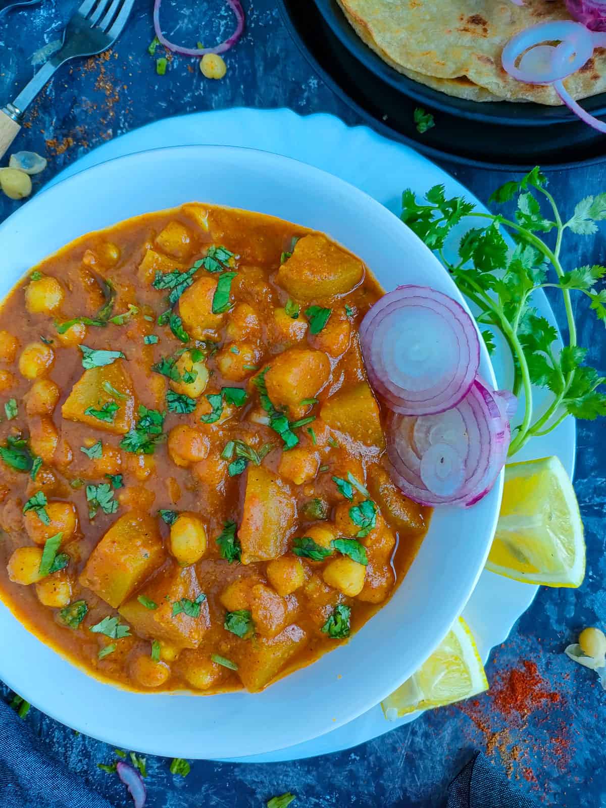 Chana aloo curry in a white bowl.