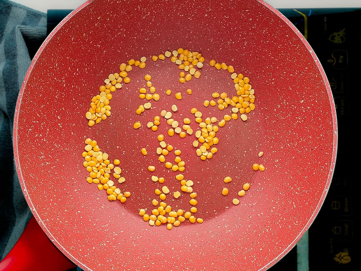 Dal (split lentils) in a pink wok pan.