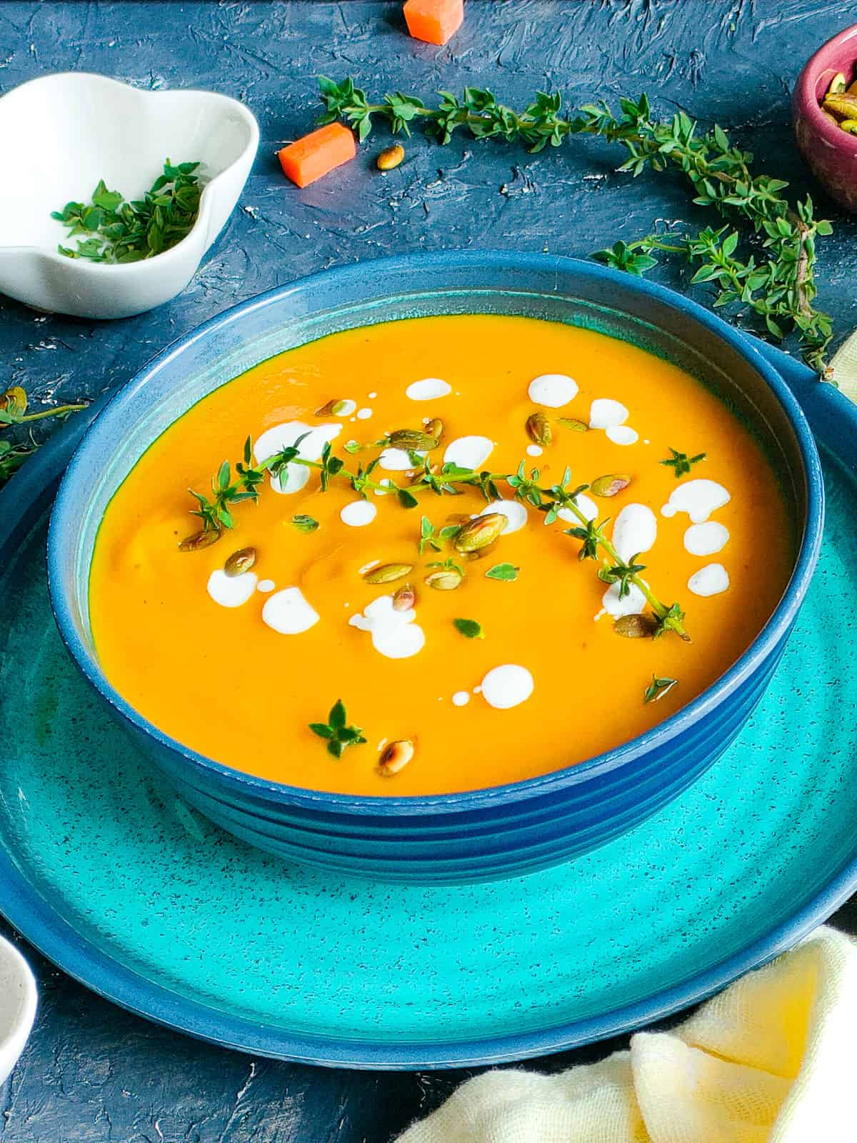 Pumpkin carrot ginger soup in a blue bowl.