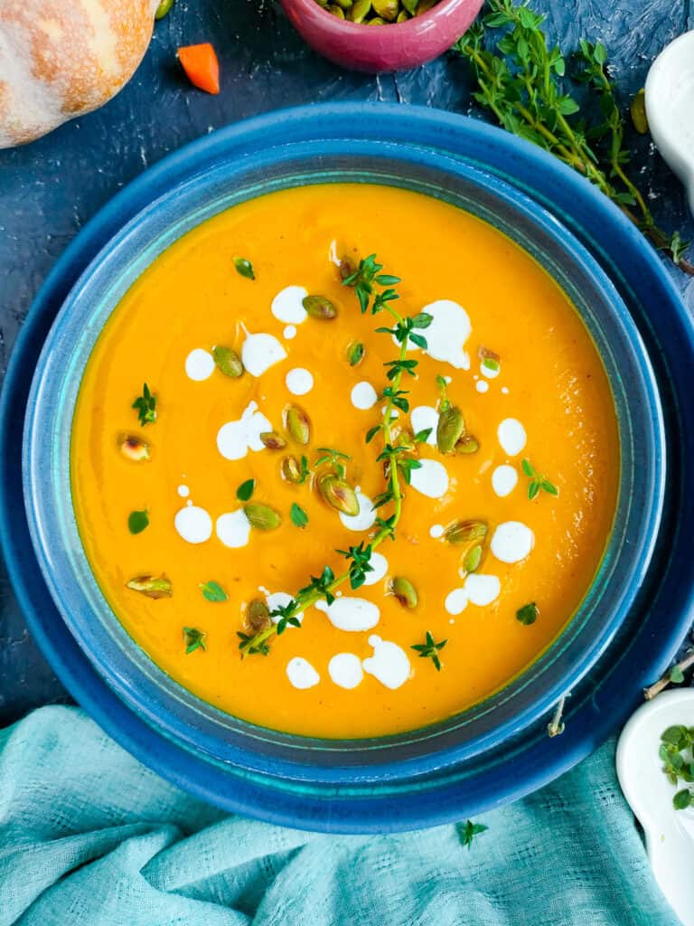 Carrot pumpkin soup in a blue bowl.