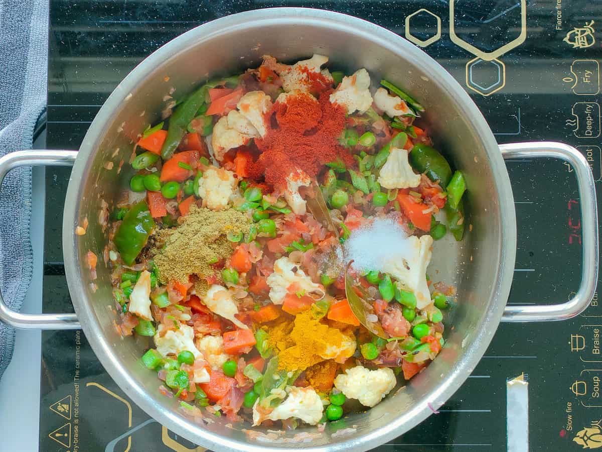 Mixed vegetables with spices in a large pot.