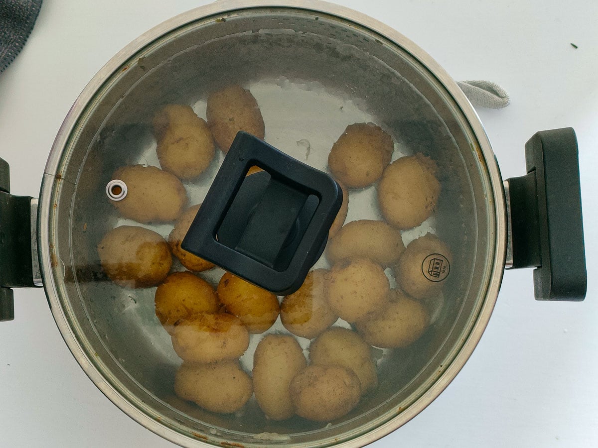 Boiled and drained petite potatoes in a large covered pot.