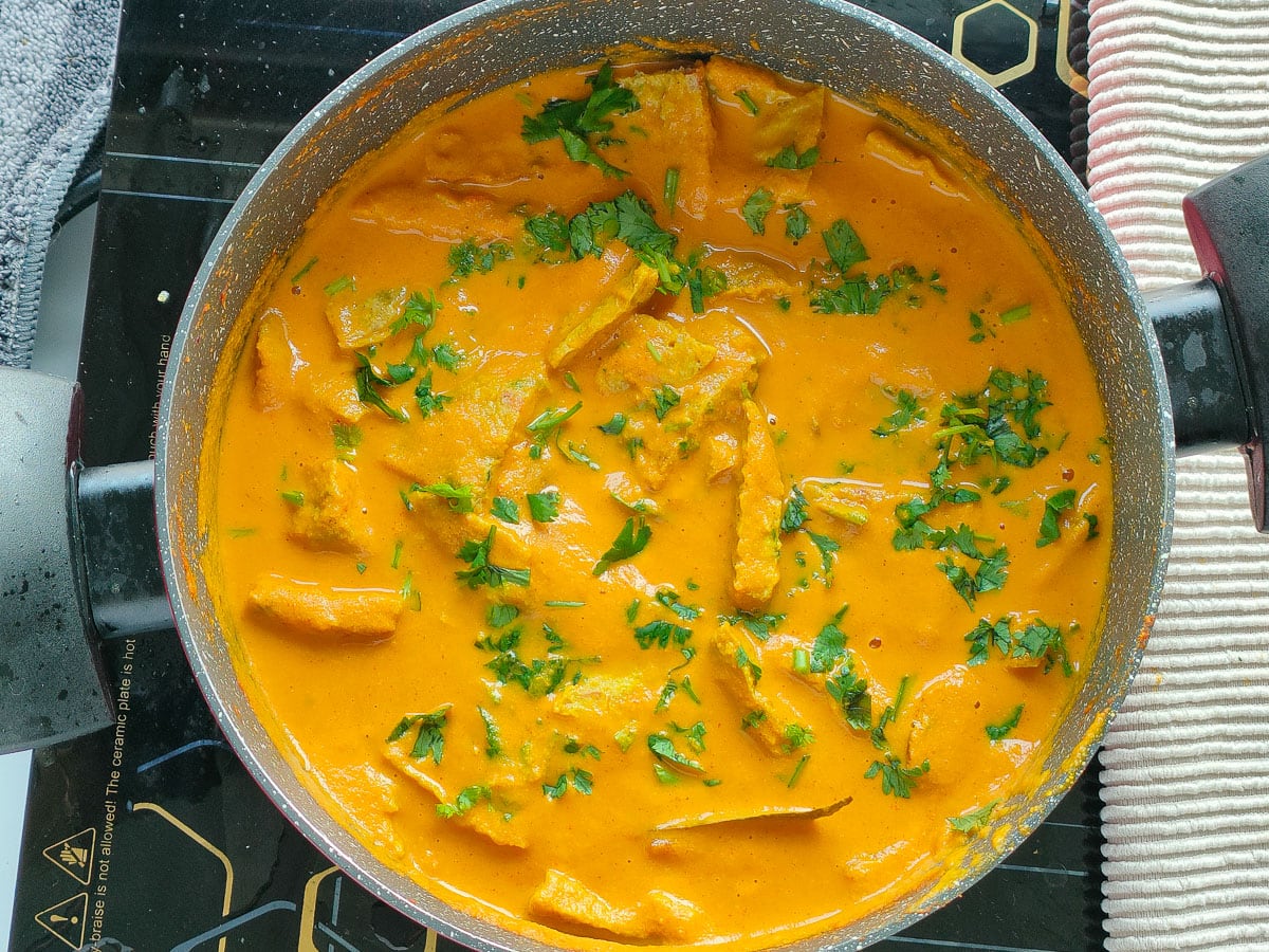 Egg omelet curry garnished with coriander leaves in a pot.