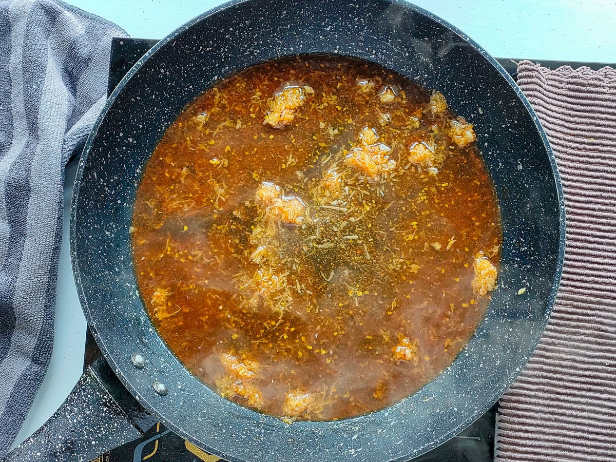 Honey garlic lemon pepper sauce simmering in a frying pan.