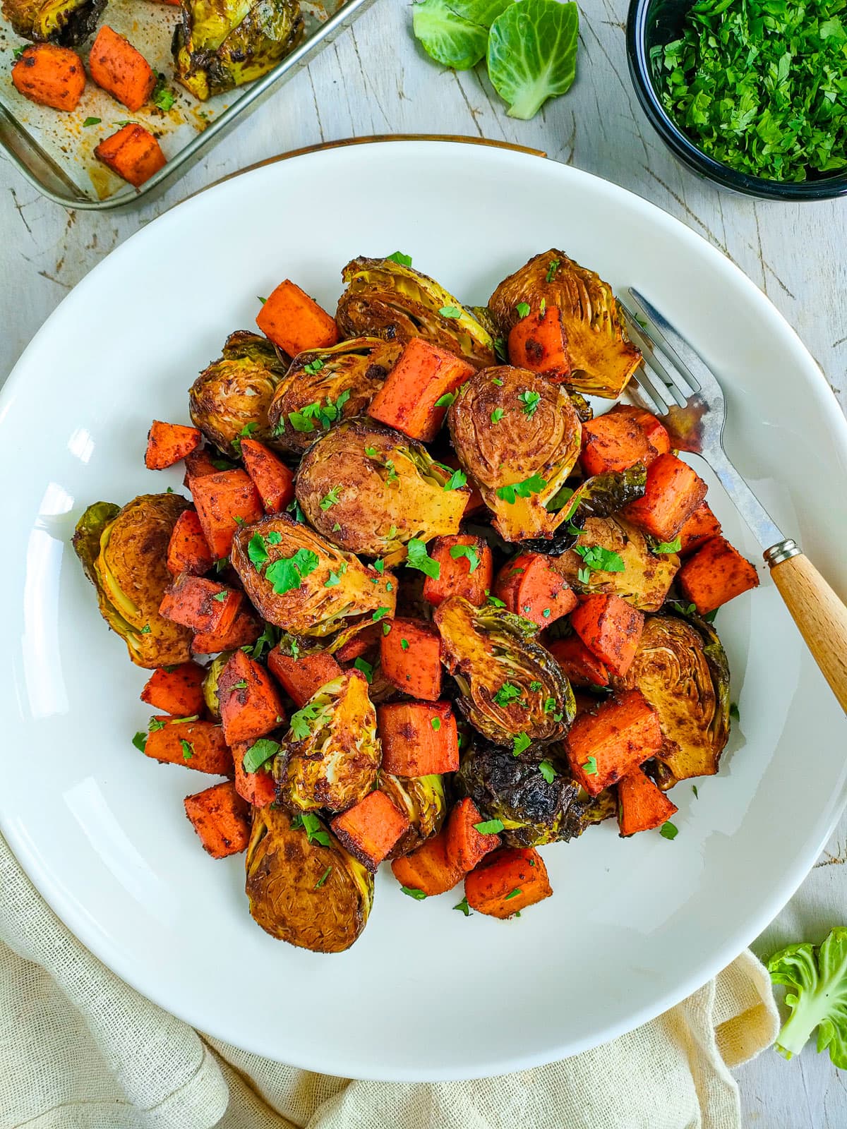 Balsamic roasted brussels sprouts and carrots on a white plate.