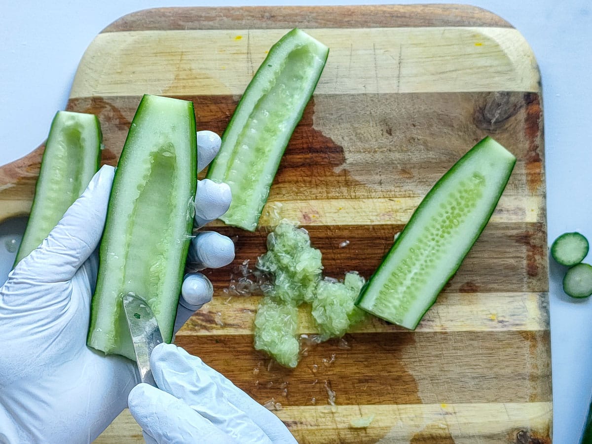 Pulp of the cucumber being scraped with a spoon.