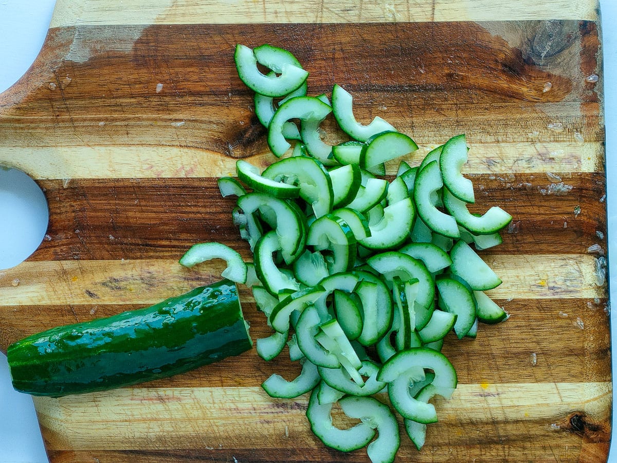 Cucumber slices on a chopping board.