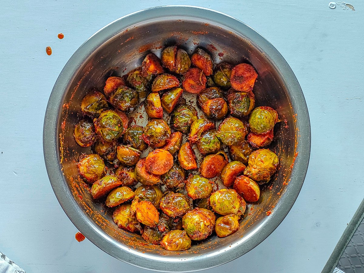 Brussels sprouts tossed with the sauce made from the marinade in a large bowl.