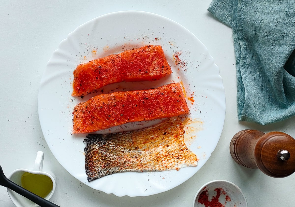 Salmon seasoned with spices and separated salmon skin.
