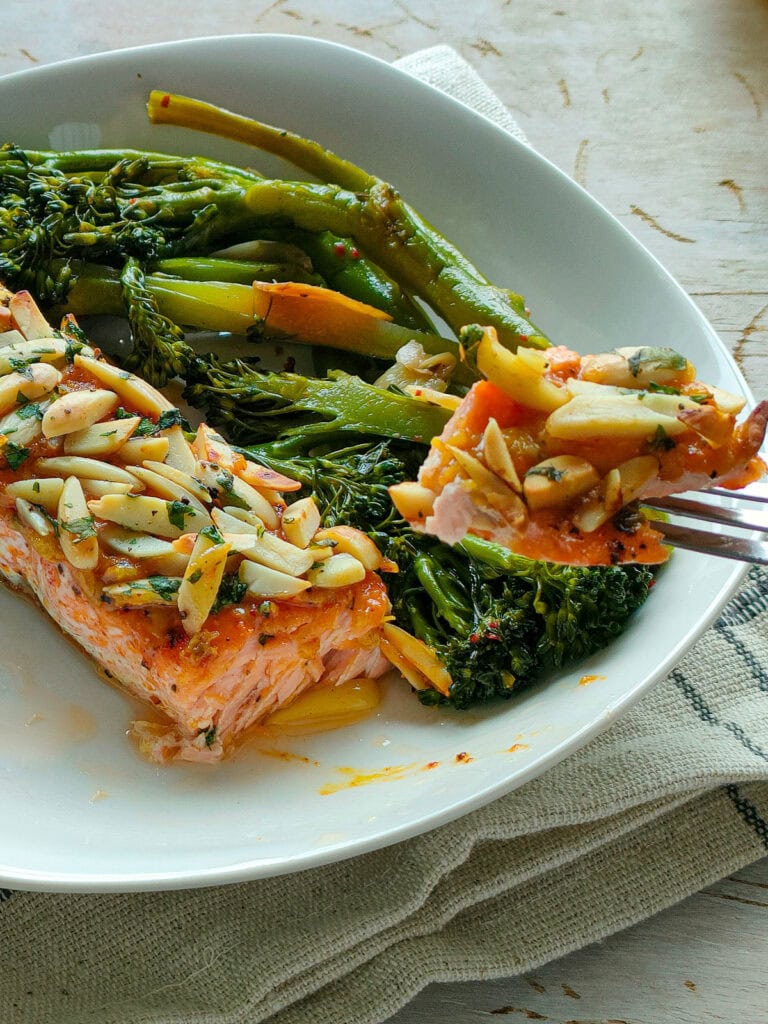 Baked almond salmon with broccolini on a plate.