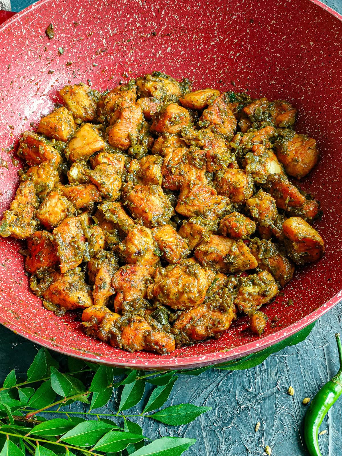 South Indian chicken with curry leaves in a deep pan.